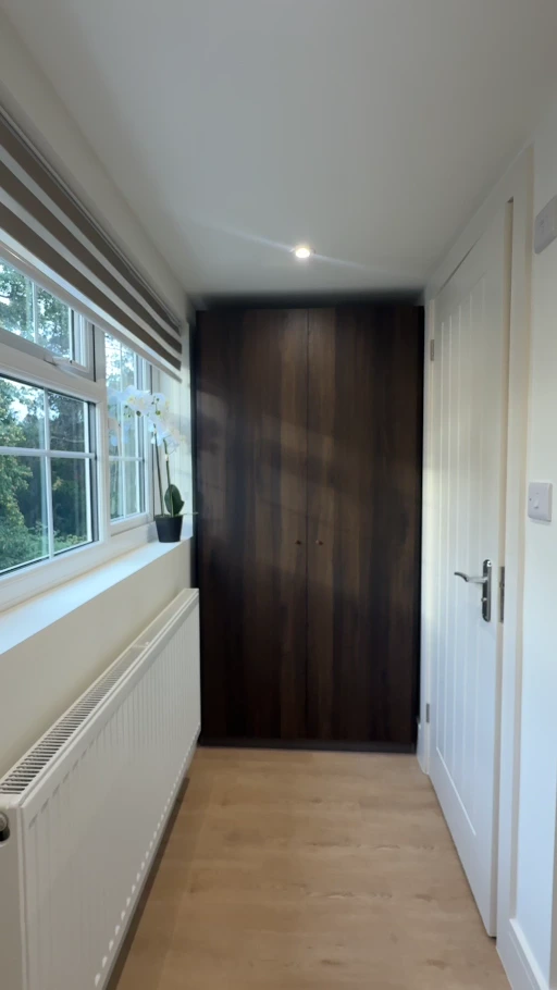 Completed hallway with light painted walls, white door and a long window